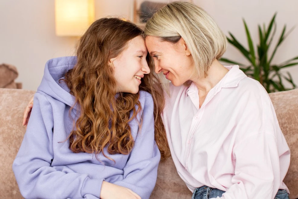 Two women smiling while looking at each other